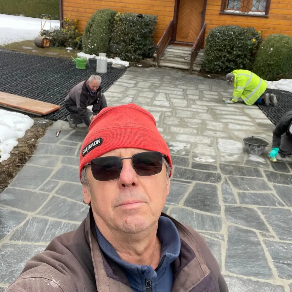 Ljubisa Jovicic sur un chantier de dallage, son équipe au travail derrière lui